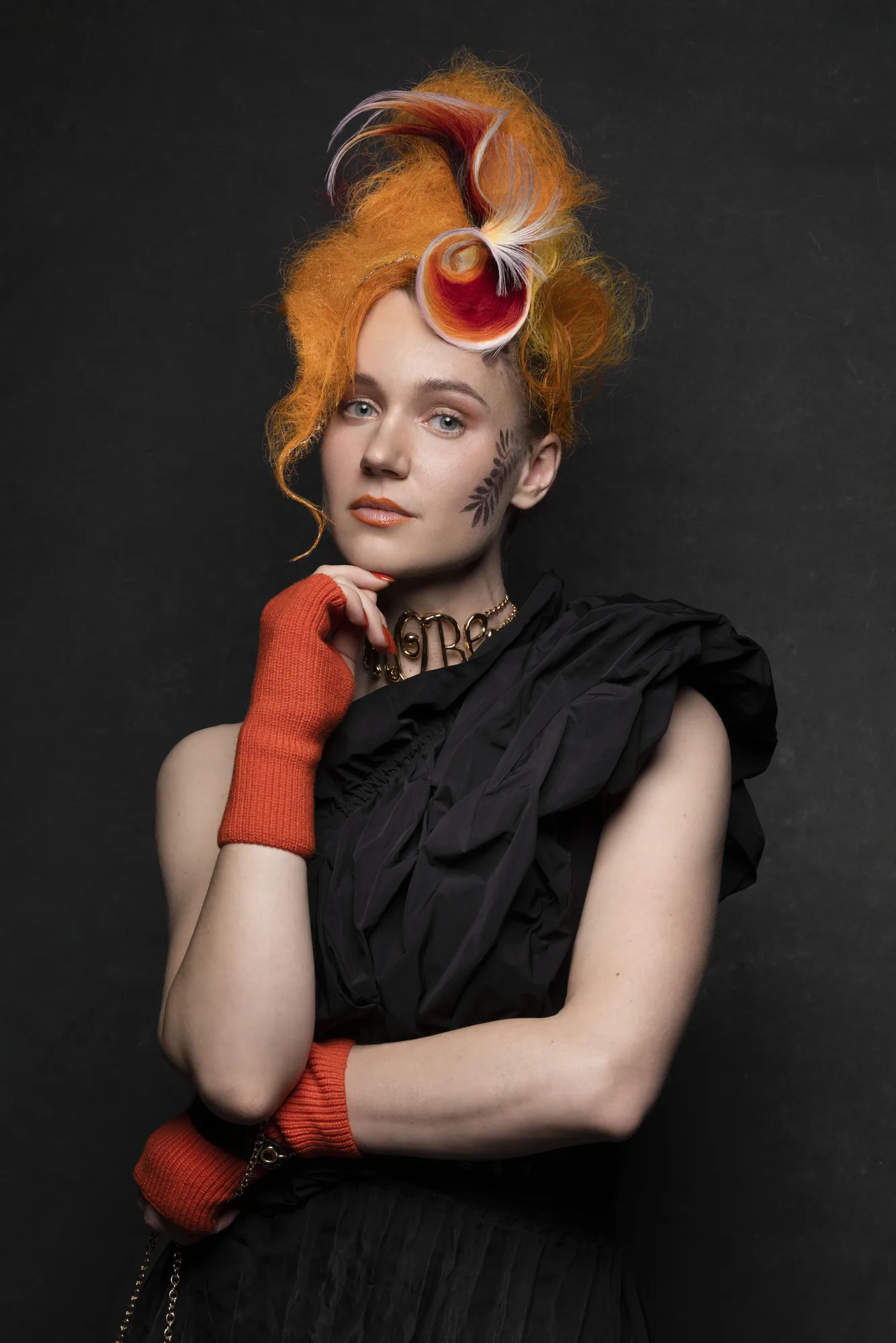 Ania Nova editorial portrait with sculpted orange hair and red gloves
