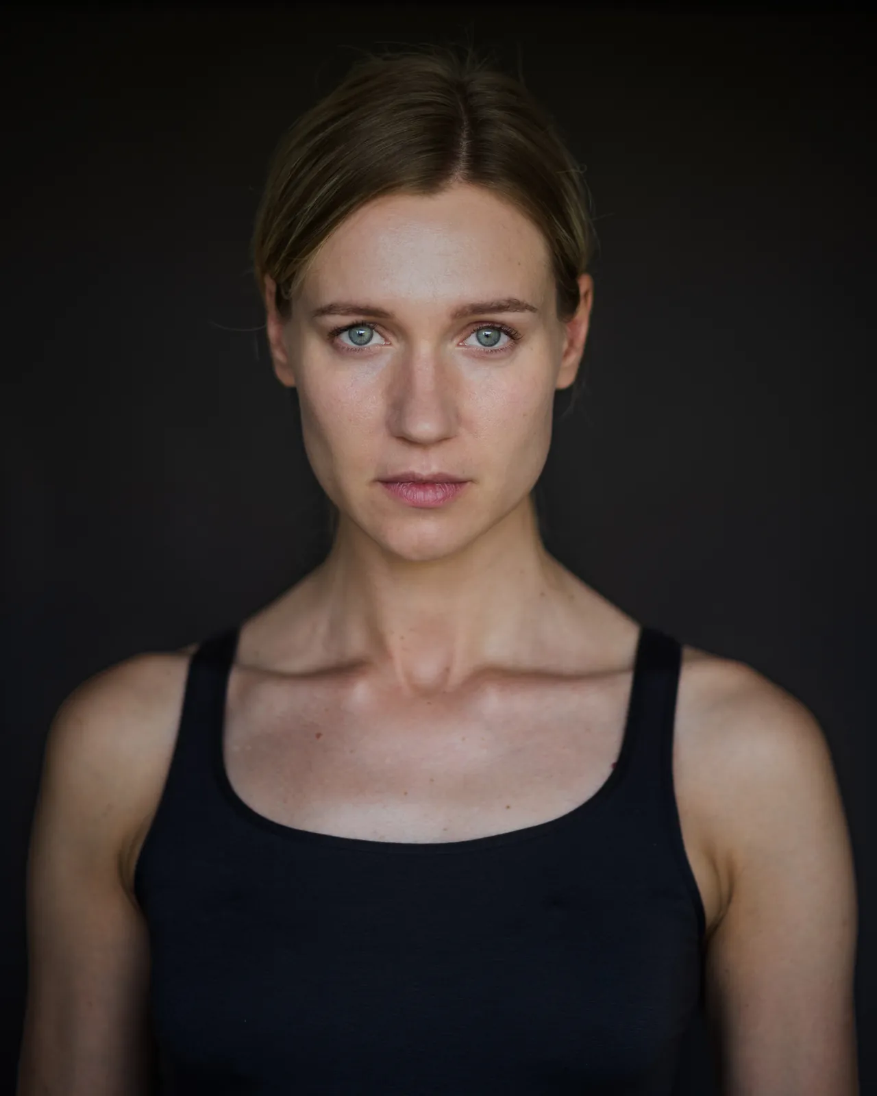 Ania Nova headshot in a black tank top against a dark backdrop